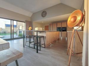 a kitchen with wooden cabinets and a clock on the wall at The Willows - Ukc4617 in Dunholme +5 photos