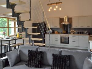 a living room with a couch and a spiral staircase at Caffi Sali - Weluk143 in Blaenpenal