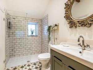a bathroom with a sink and a toilet and a mirror at Greenbank Farm in Weeton