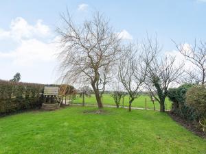 a field with trees and a sign in the grass at Greenbank Farm in Weeton