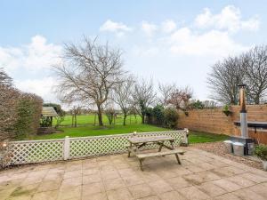 a wooden bench sitting on a patio next to a fence at Greenbank Farm in Weeton