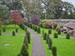 a path through a garden with trees and bushes at Garden Cottage in Westleigh