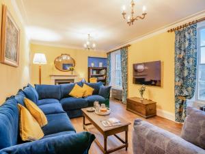 a living room with a blue couch and a table at Rock House in Wells
