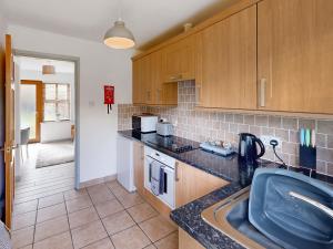 a kitchen with a sink and a counter top at Elm Cottage-Uk2791 in Penmaen-mawr