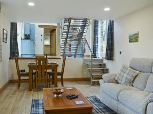 a living room with a couch and a table at Bluebell Barn in Okehampton