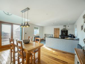 a kitchen and dining room with a table and chairs at Deri Cottage in Chwilog