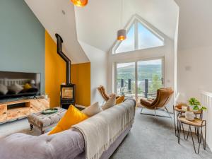 a living room with a couch and a large window at Shoreside in Aberfeldy
