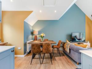 a dining room with a table and chairs and a couch at Shoreside in Aberfeldy