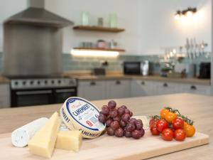 a cutting board with cheese and vegetables on a kitchen counter at The Barn At Toft Hill Hall in High Etherley
