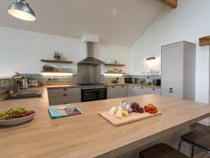 a kitchen with a counter with a cutting board with fruit on it at The Barn At Toft Hill Hall in High Etherley +9 photos