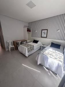 a bedroom with two beds and a table and a chair at Scaini Palace Hotel in Arroio do Silva +52 photos