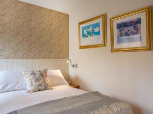 a bedroom with a bed and two pictures on the wall at Courtyard - Uk7554 in Inverness +9 photos