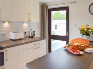 a kitchen with a table with a plate of food on it at Sunset in Cheriton Bishop