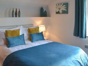 a bedroom with a blue and white bed with pillows at Sunset in Cheriton Bishop +11 photos