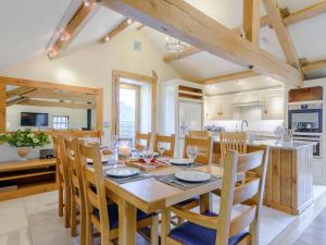 a kitchen and dining room with a wooden table and chairs at Mungeon Barn - Uk30125 in Backbarrow