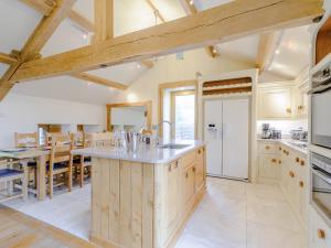 a kitchen with wooden cabinets and a large island at Mungeon Barn - Uk30125 in Backbarrow