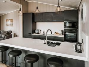 a kitchen with black cabinets and a counter with stools at Elmore - Uk51111 in Clitheroe