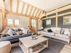 a living room with two couches and a table at Lovington Barn in Ovington