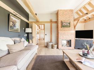 a living room with a couch and a fireplace at Lovington Barn in Ovington +27 photos