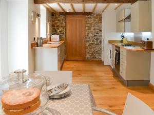 a kitchen with a table with a cake on it at The Oak Stall - Uk11023 in East Worlington