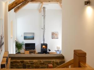 a living room with a stone fireplace and a stove at The Oak Stall - Uk11023 in East Worlington