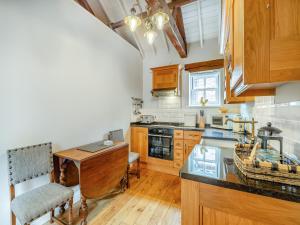 a kitchen with wooden cabinets and a wooden table at The Stables - Uk47151 in Burgh le Marsh