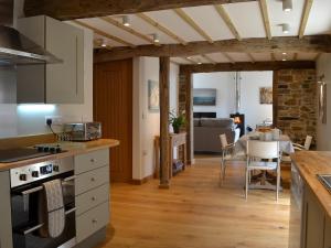 a kitchen and living room with a table and chairs at The Oak Stall - Uk11023 in East Worlington