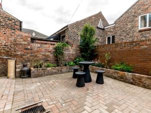 a patio with a table and stools in front of a brick wall at Priory Street in York