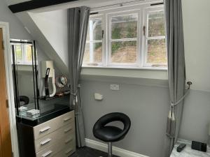a room with a chair and a desk and a window at Cherrywood Lodge in Looe +65 photos