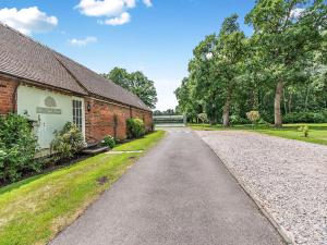 an empty road next to a brick building at The Pool House - Uk49372 in Send