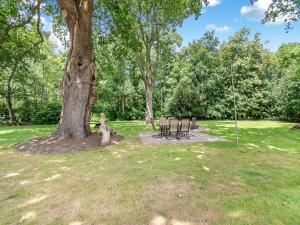 a park with a table and chairs under a tree at The Pool House - Uk49372 in Send +16 photos