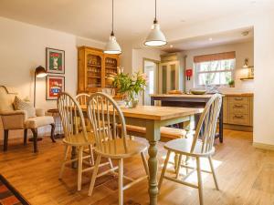 a kitchen and dining room with a wooden table and chairs at Gatehouse North in Worstead