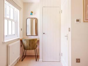 a dressing room with a chair and a mirror at Gatehouse North in Worstead +9 photos