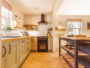 a kitchen with white cabinets and a black oven at Gatehouse North in Worstead
