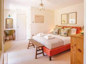 a bedroom with a large bed and a desk at Gatehouse North in Worstead