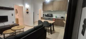 a living room with a couch and a table and a kitchen at Aleka Apartment in Kos