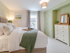 a bedroom with a white bed and a window at Mrs Cracker's Cottage in Lund