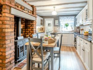a kitchen with a table and chairs and a brick wall at Mrs Cracker's Cottage in Lund