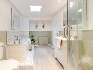 a bathroom with a tub and a toilet and a sink at Mrs Cracker's Cottage in Lund +11 photos