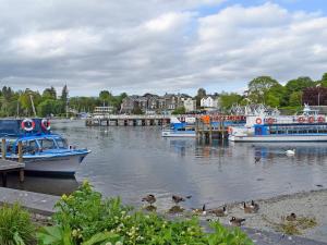 two boats docked at a dock with ducks in the water at The Old Chapel in Ulverston