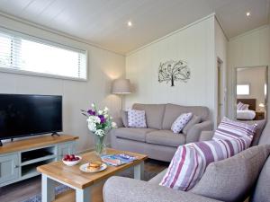 a living room with a couch and a tv at Holly Lodge in Hassocks