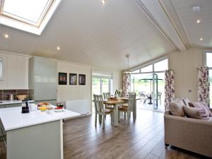 a kitchen and living room with a table and chairs at Holly Lodge in Hassocks