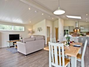 a living room and dining room with a couch and a table at Holly Lodge in Hassocks