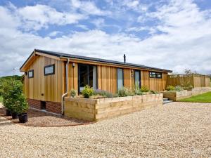 a small wooden house with a retaining wall at Holly Lodge in Hassocks