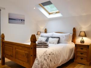 a bedroom with a wooden bed with a skylight at Bryn Aled in Llanfachreth