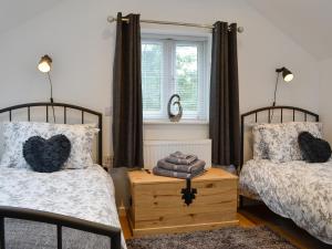 a bedroom with two beds and a window at Bryn Aled in Llanfachreth +5 photos