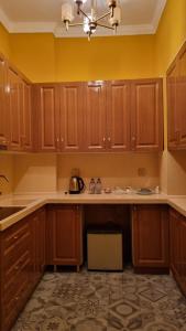 a kitchen with wooden cabinets and a counter top at Grand Hotel 1902 in Baku