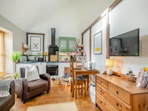 a living room with a couch a table and a tv at The Dairy - Ukc3780 in Hickling