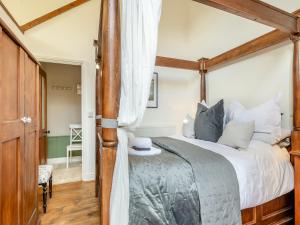 a bedroom with a large bed with a wooden frame at The Dairy - Ukc3780 in Hickling