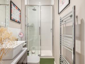 a bathroom with a shower and a toilet and a sink at The Dairy - Ukc3780 in Hickling